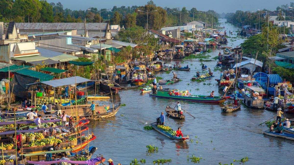 Boats loaded with produce trading on the water at a floating market in the Mekong Delta, Sóc Trăng p